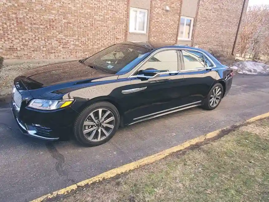 Sleek black Lincoln Continental parked outside, showcasing its bold front grille