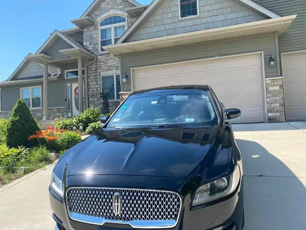 Luxury black town car parked curbside, ready for executive transport with sleek, polished exterior