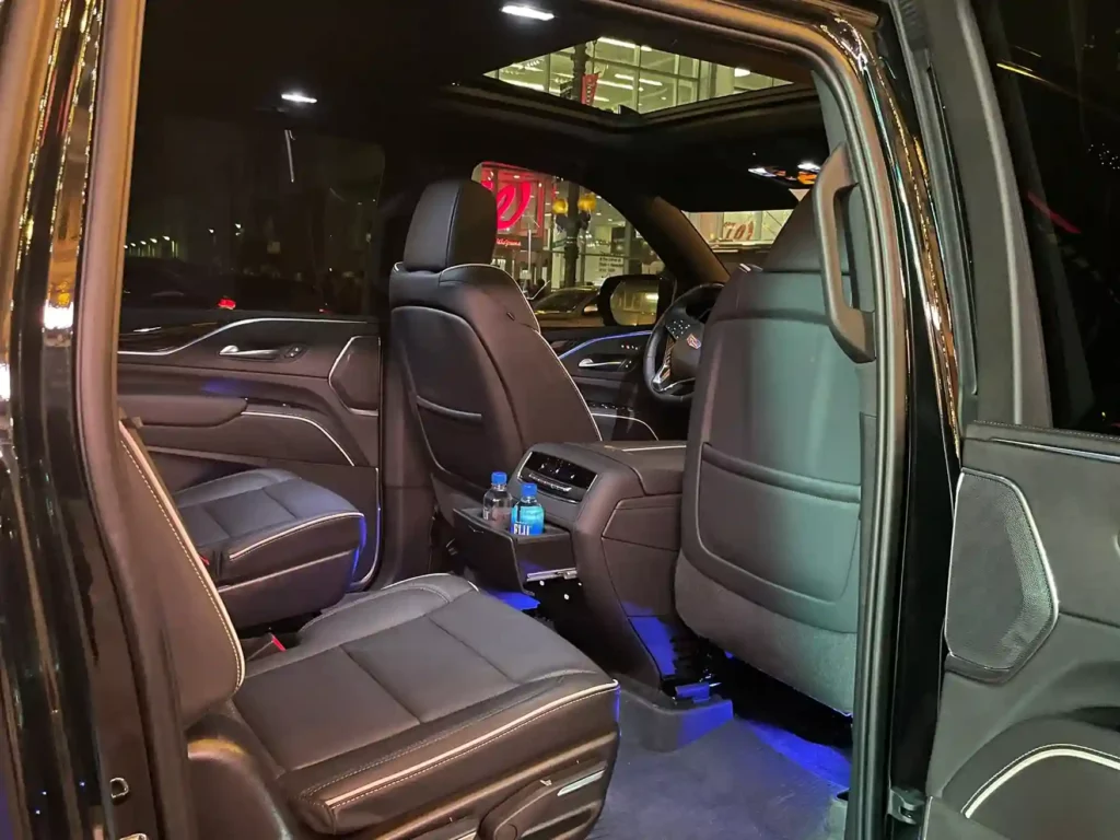 Luxurious black SUV interior featuring leather seats, sleek dashboard, and ambient lighting