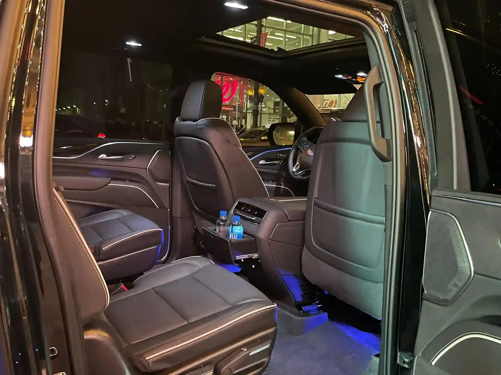 Luxurious black SUV interior featuring leather seats, sleek dashboard, and ambient lighting